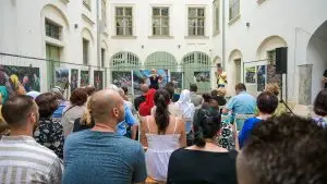 Geigenspielerin bei der Eröffnung der Ausstellung vor einem sitzenden Publikum